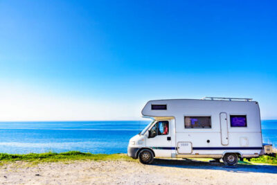 Camper rv caravan on mediterranean coast in Spain. Wild camping on sea shore. Holidays and travel in motor home.
